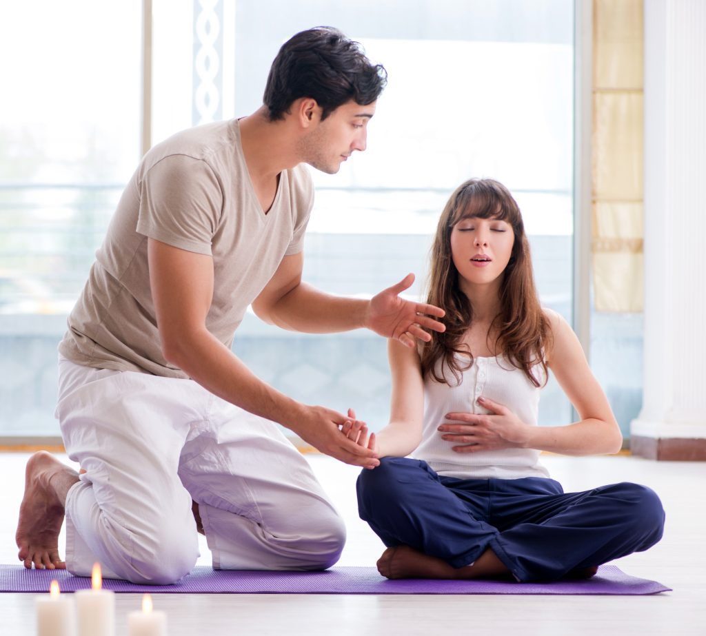 Coach helps the girl during yoga