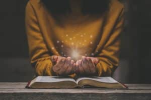 Woman Prayings On Spiritual-Book